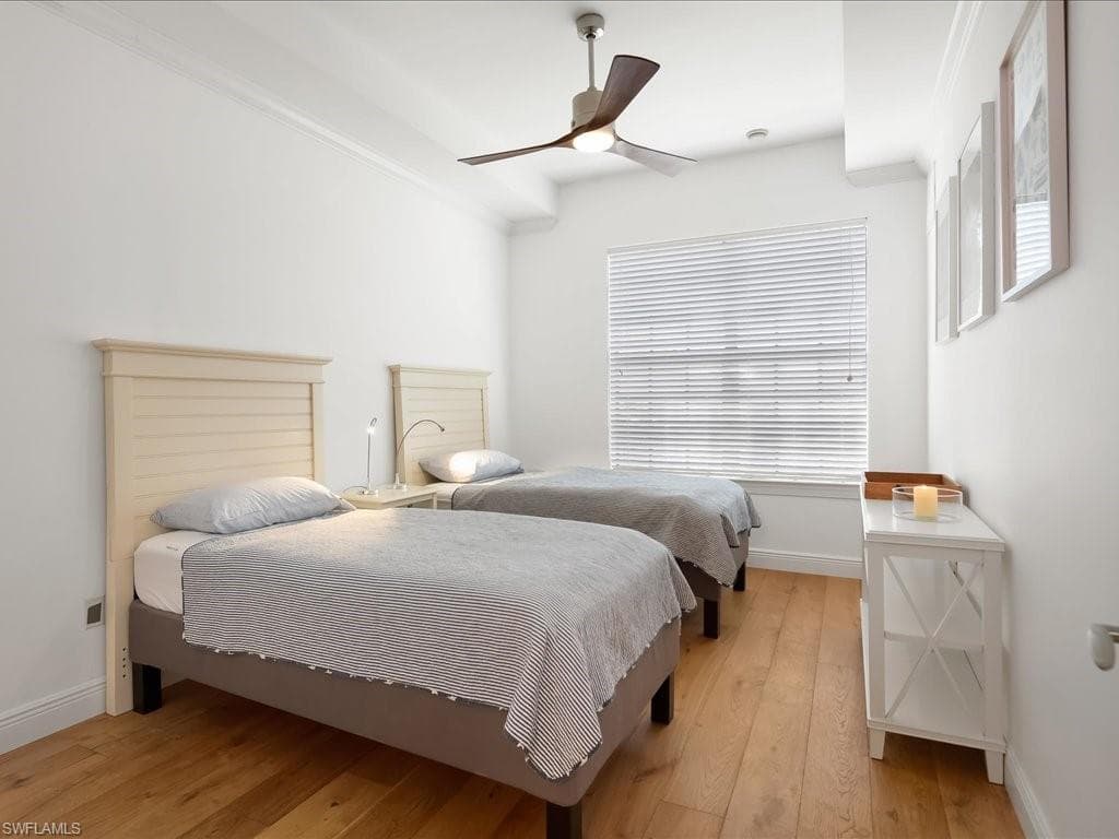 Bedroom featuring light wood-style flooring, ceiling fan, and multiple windows