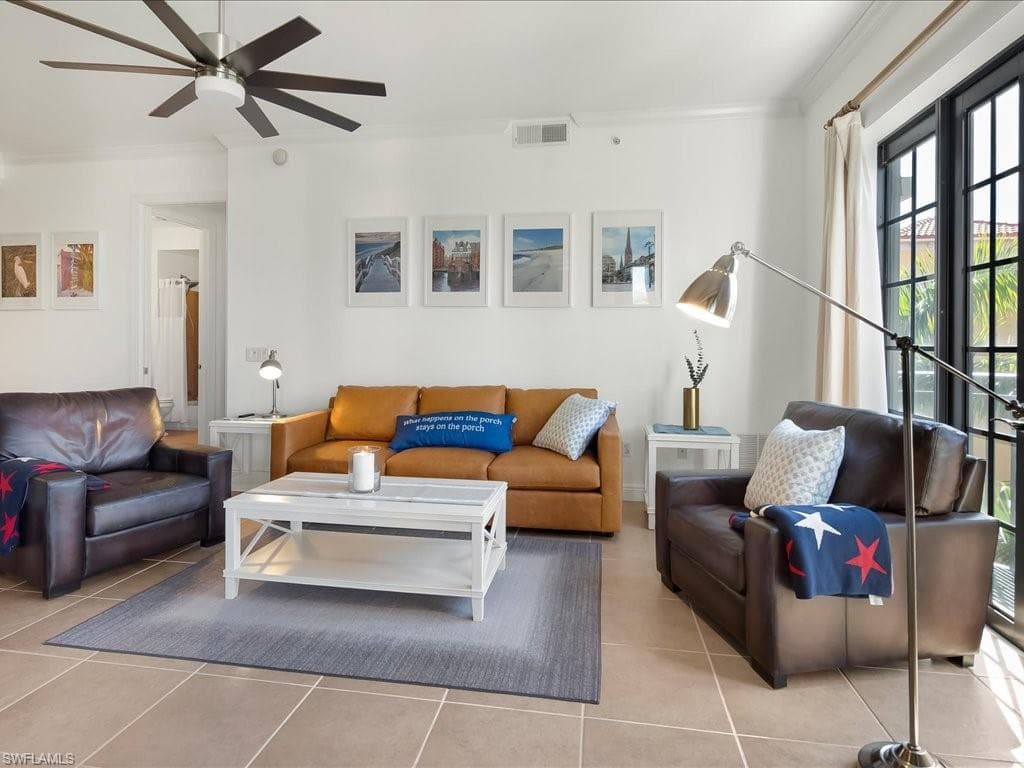 Living area with crown molding, tile patterned floors, and a ceiling fan