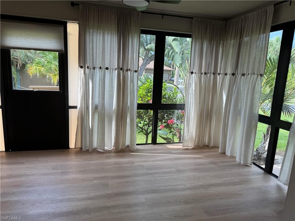 GLASSED IN SUN ROOM SHOWING SIDE ENTRANCE STORM DOOR TO SIDE YARD