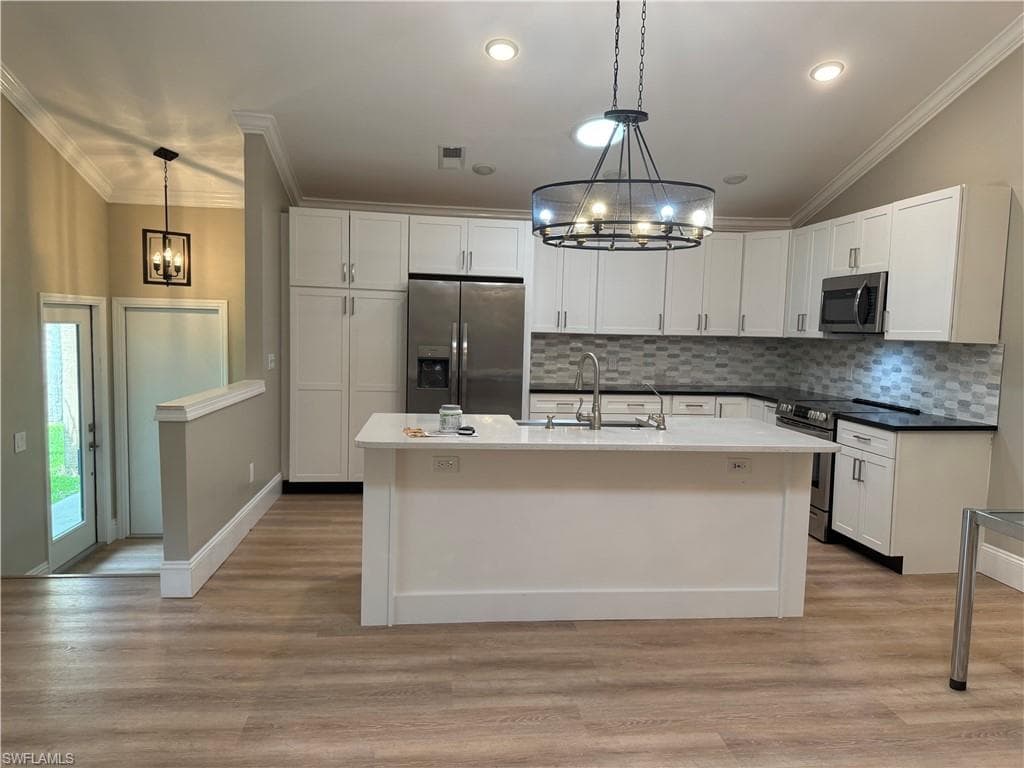KITCHEN AND SHOWING 2 STEPS DOWN TO THE FOYER AND FRONT SIDE DOOR ENTRANCE