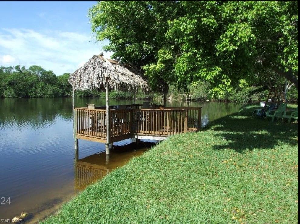 Dock area with a yard and a water view