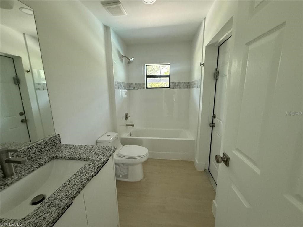 Full bath with vanity, shower / washtub combination, and light wood-type flooring