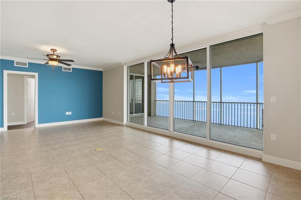 Dining/Living area with floor to ceiling windows, a ceiling fan, crown molding, a chandelier, and light tile floors