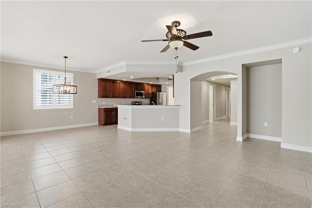 Living/Dining area room featuring floor to ceiling windows, ornamental molding, ceiling fan, and light tile floors