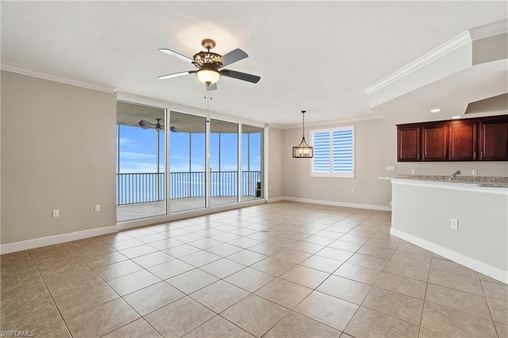 Living/Dining area room featuring floor to ceiling windows, ornamental molding, ceiling fan, and light tile floors