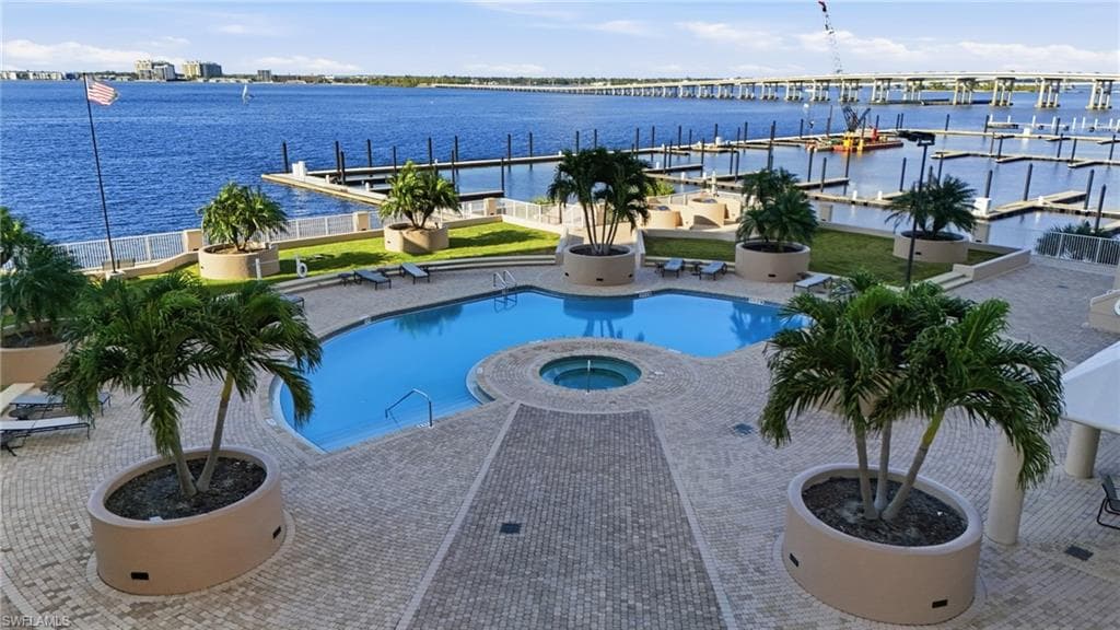 Community pool with a community hot tub, a patio, and a water view
