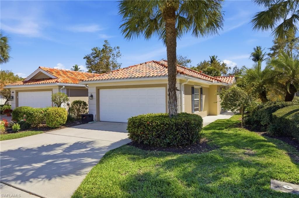 Tropical curb appeal, the Capri villa with tile roof and two car garage on a quiet Village Walk street