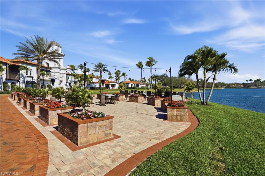 Scenic community gathering area with outdoor seating overlooking the pond.