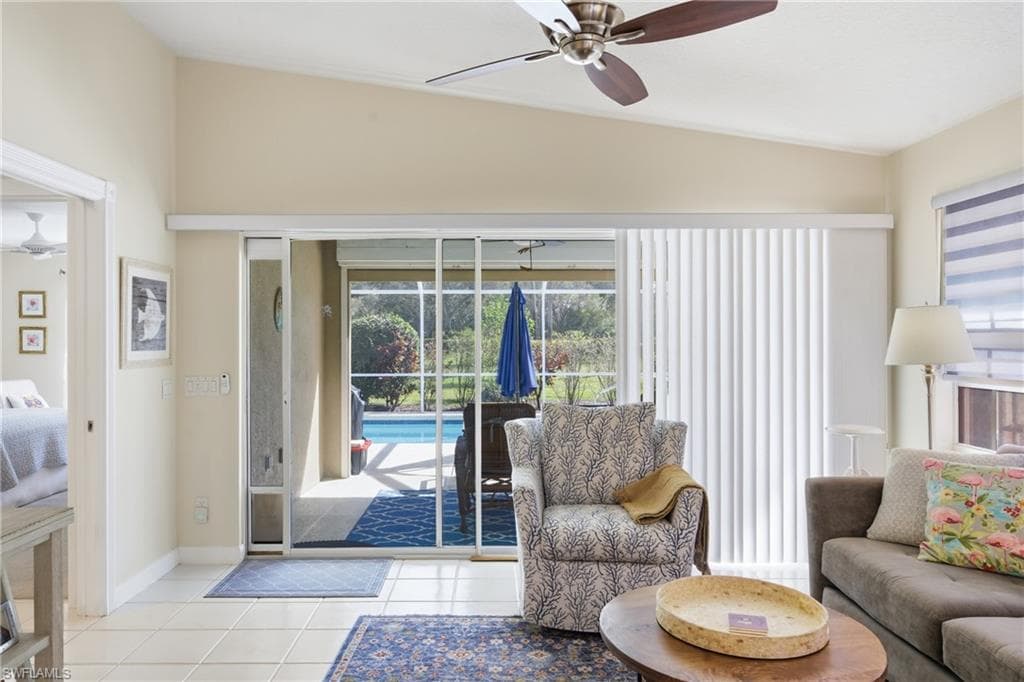 Bright living area with large sliding doors that open directly to the screened lanai and pool.