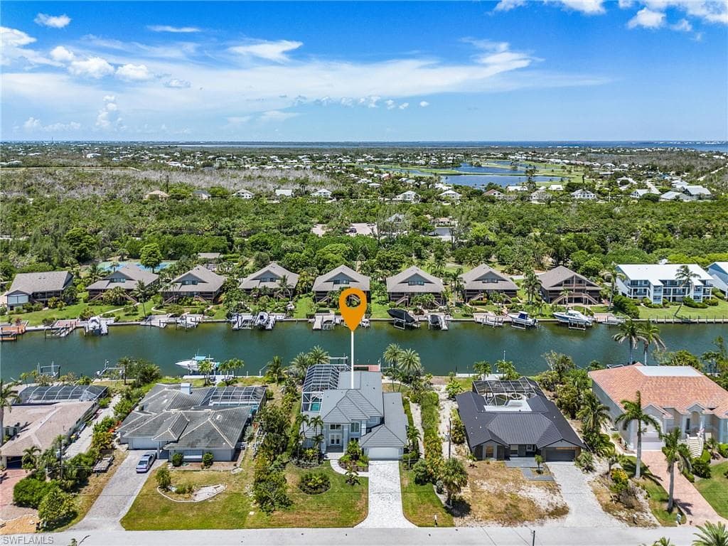 Aerial view of residential area featuring a tree filled landscape and a large body of water
