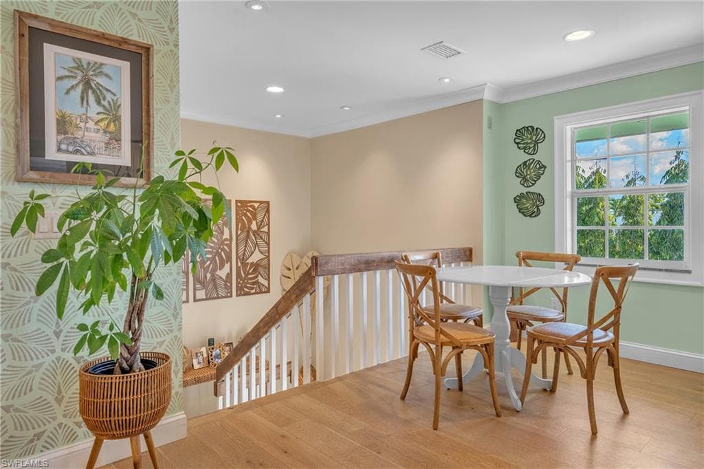 Dining space featuring crown molding, wood finished floors, and recessed lighting