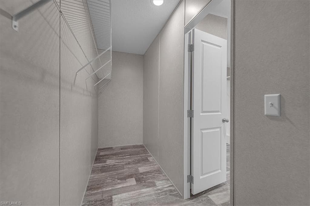 Walk in closet with light wood-style flooring