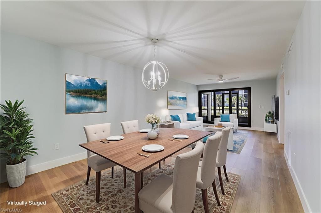 Dining area with a ceiling fan, light wood-style floors, and a chandelier