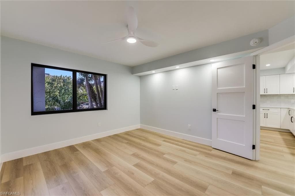 Spare room with a ceiling fan and light wood-style floors