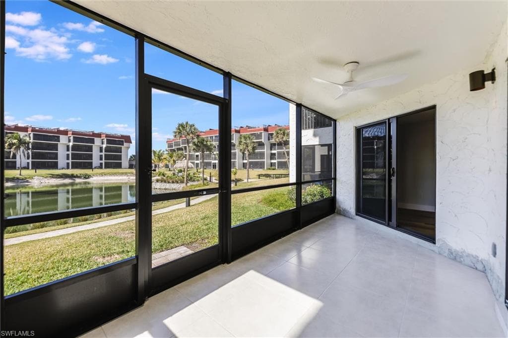 Unfurnished sunroom featuring a ceiling fan