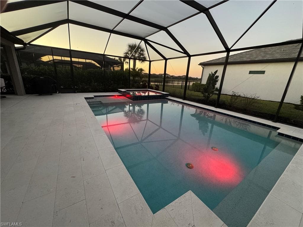Integrated pool / hot tub with a lanai, a sunroom, and a patio