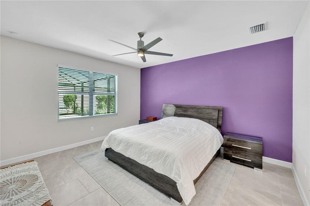 Bedroom with a ceiling fan and an accent wall