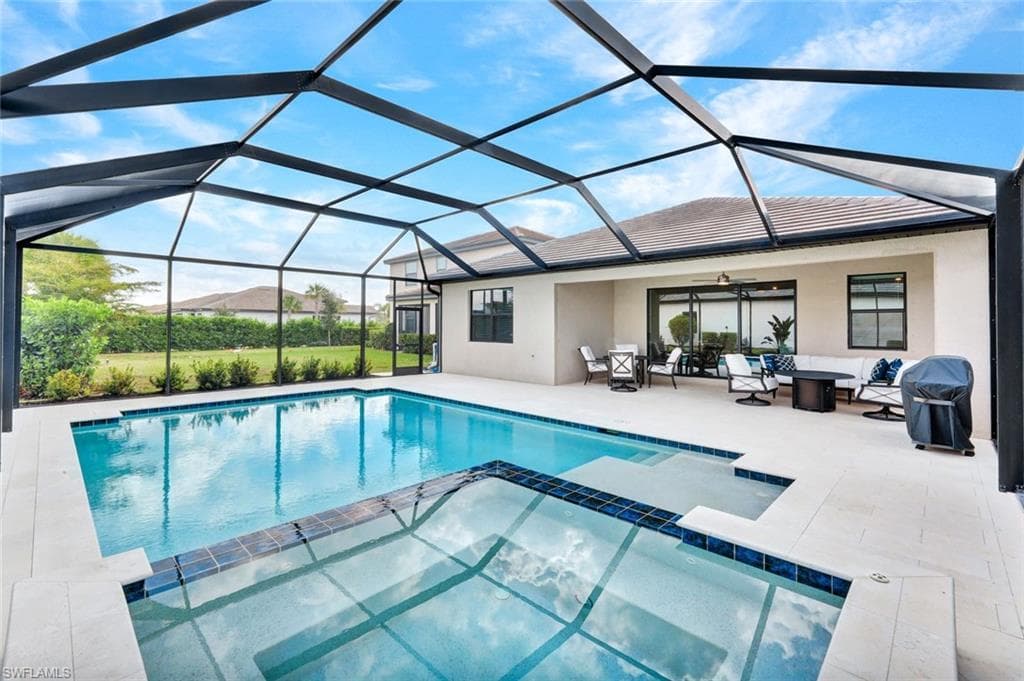 Relaxing pool / spa with outdoor lounge area, a sunroom, and a lanai
