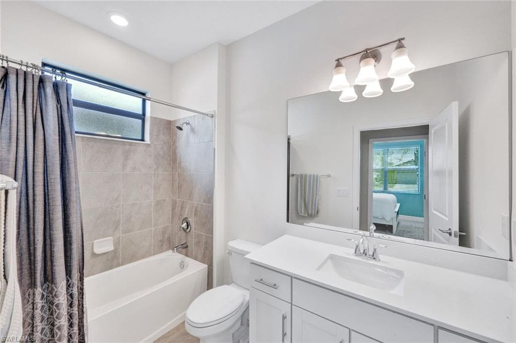 Full bath with plenty of natural light, ensuite bathroom, vanity, and shower / tub combo