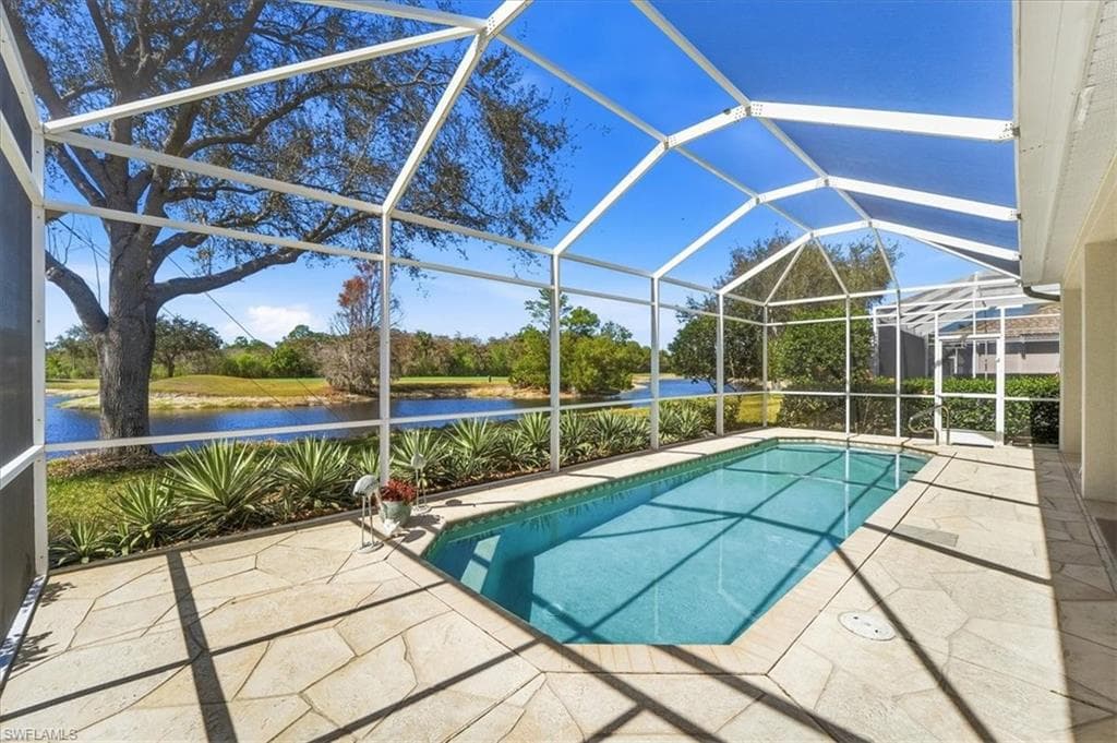 Swimming pool featuring a sunroom, a patio area, glass enclosure, and a water view