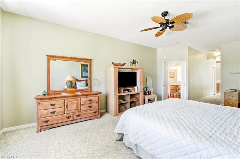 Carpeted bedroom with a ceiling fan and baseboards