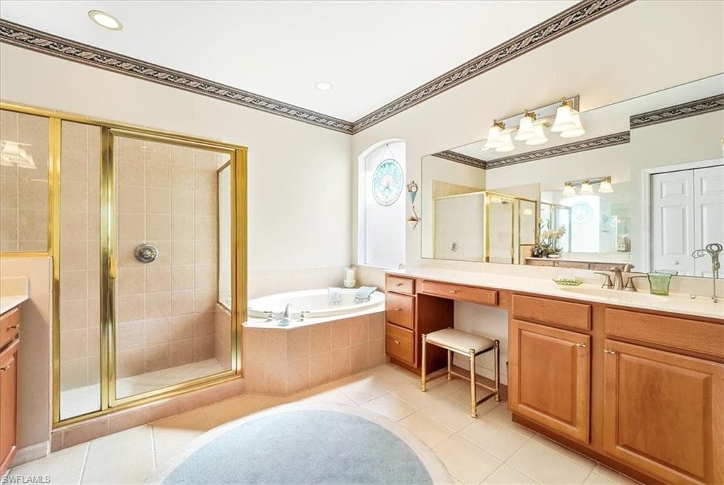 Full bathroom featuring vanity, a stall shower, a garden tub, and light tile patterned floors