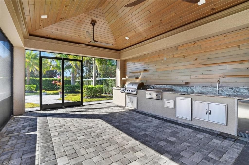Unfurnished sunroom featuring lofted ceiling and a sink
