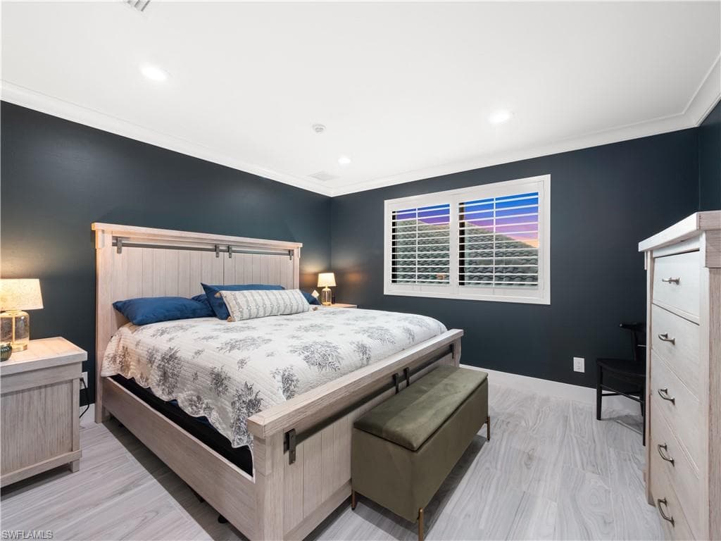 Bedroom with crown molding, light wood finished floors, and recessed lighting