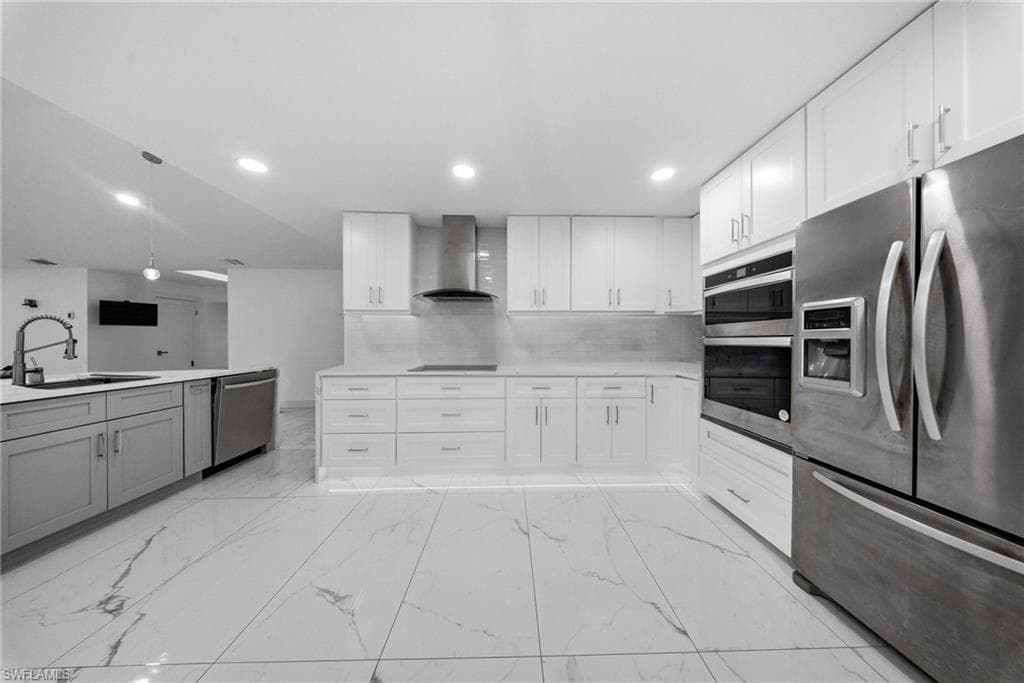 Kitchen with stainless steel appliances, white cabinetry, recessed lighting, and light marble finish flooring