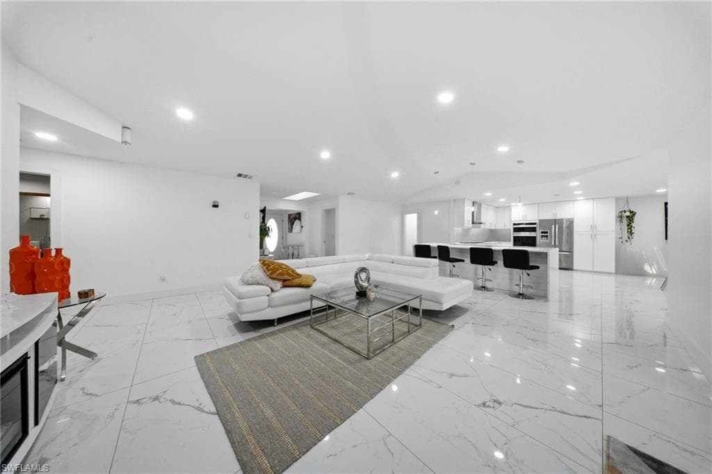 Living room with recessed lighting and light marble finish floors