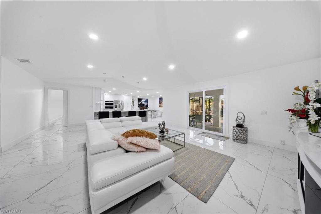Living area featuring vaulted ceiling and recessed lighting