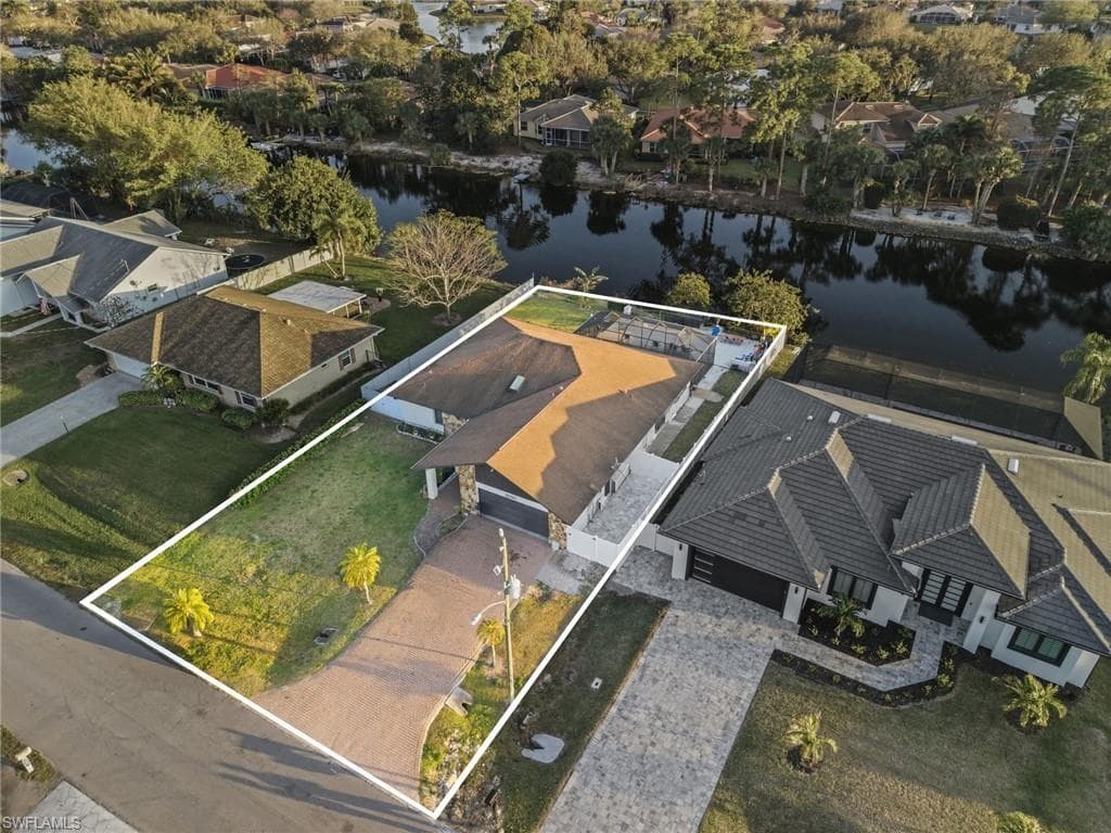 Aerial view of residential area with property parcel outlined and a large body of water