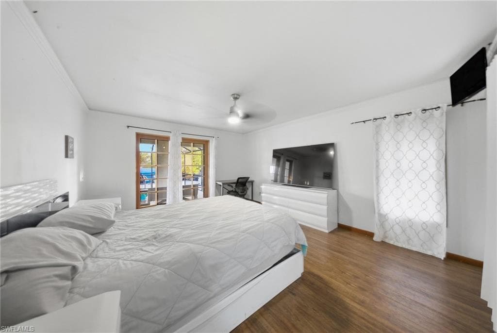 Bedroom featuring dark wood-type flooring, a ceiling fan, crown molding, and access to exterior