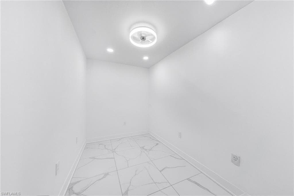 Empty room featuring light marble finish floors and recessed lighting