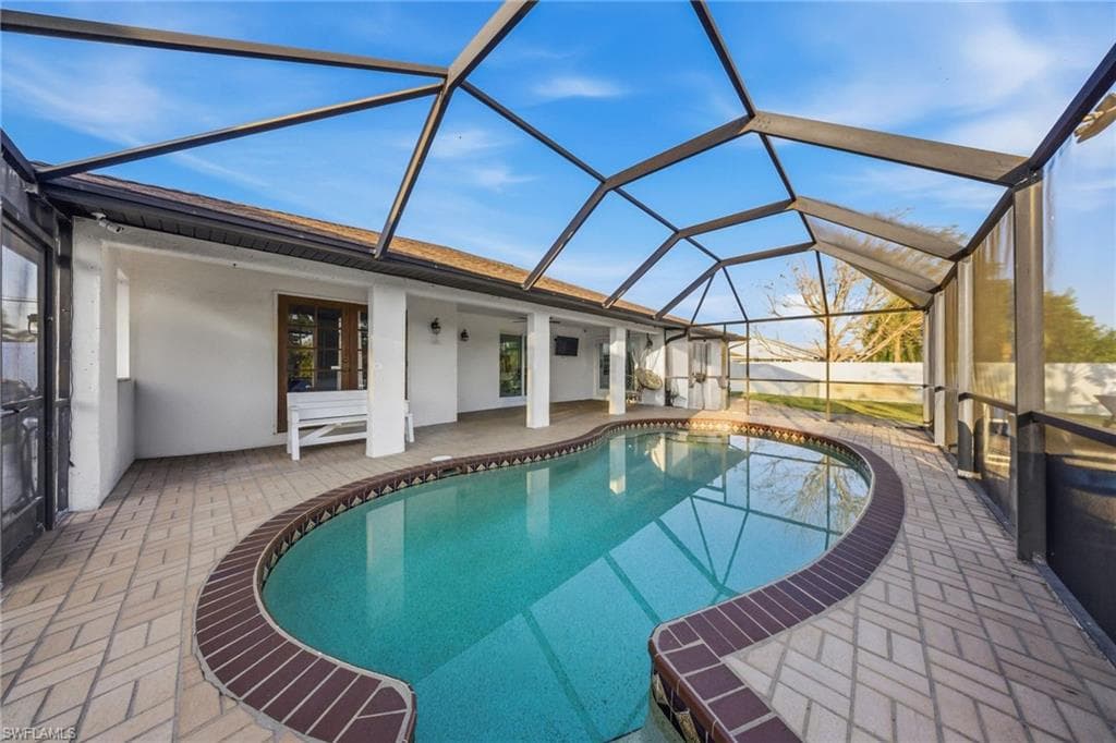Swimming pool featuring a sunroom, a patio, and a lanai