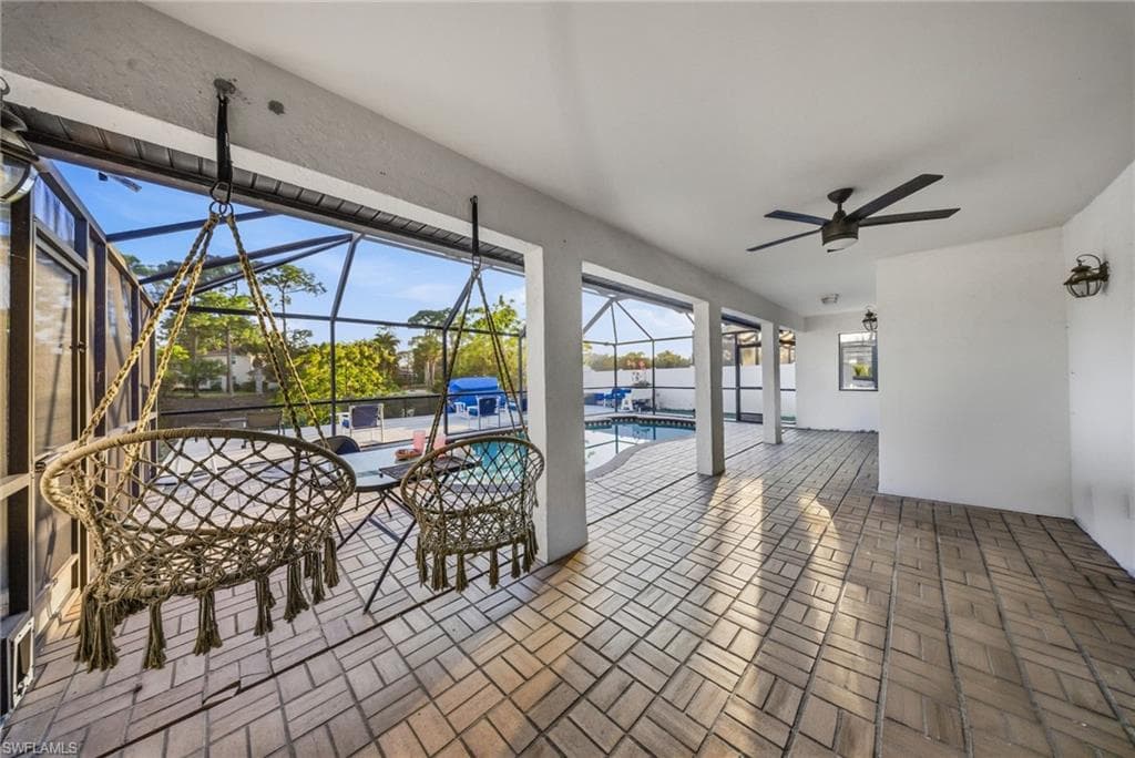 View of patio / terrace featuring a sunroom, an outdoor pool, a lanai, and a ceiling fan