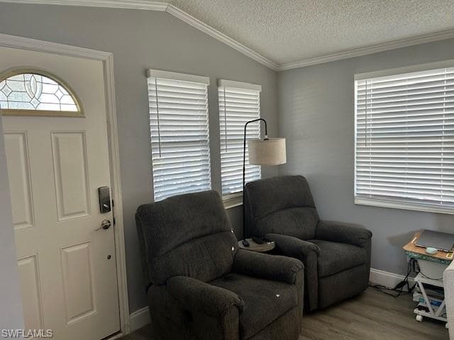 Living area with wood finished floors and ornamental molding