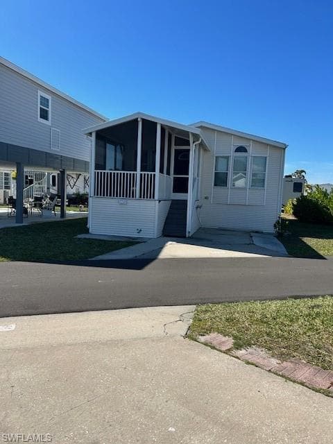 Manufactured / mobile home with a sunroom and a front yard