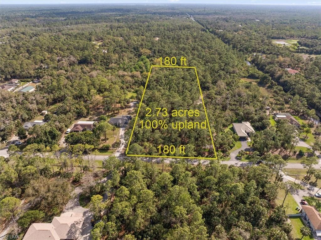 Aerial view of property and surrounding area featuring a heavily wooded area and property boundaries highlighted