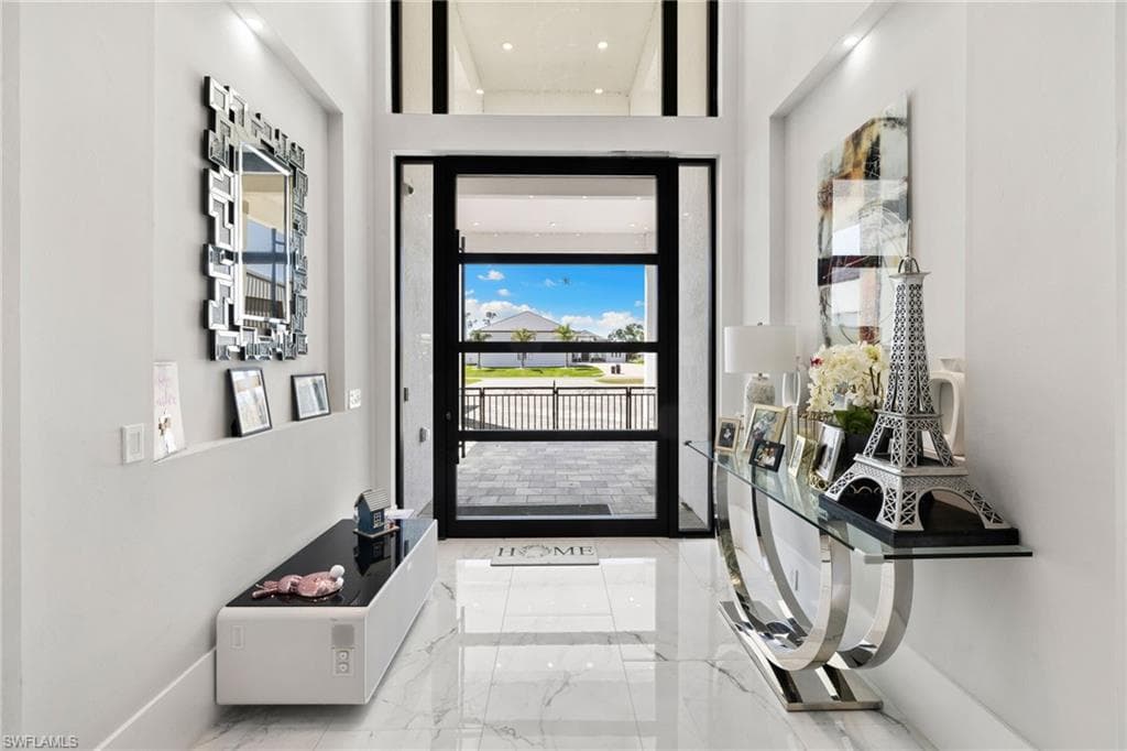 Foyer with light marble finish flooring and a high ceiling