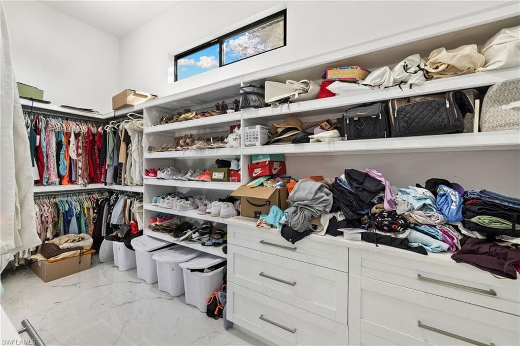 Walk in closet with light marble finish floors
