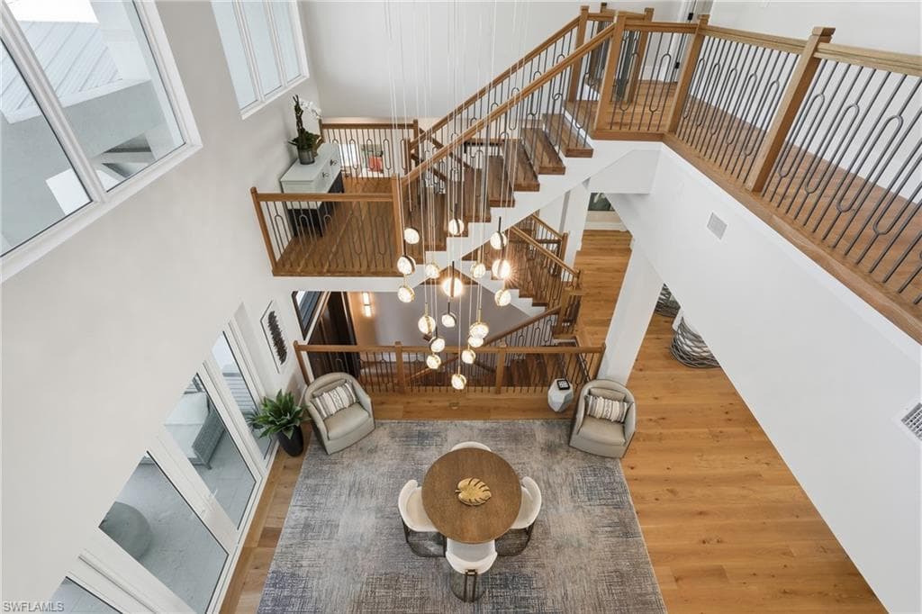 Stairway with wood finished floors and a high ceiling - Virtually Edited Image
