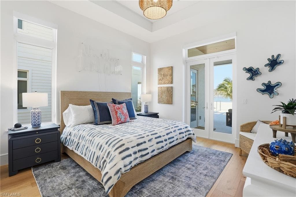 Bedroom with light wood-type flooring, french doors, and access to exterior - Virtually Edited Image