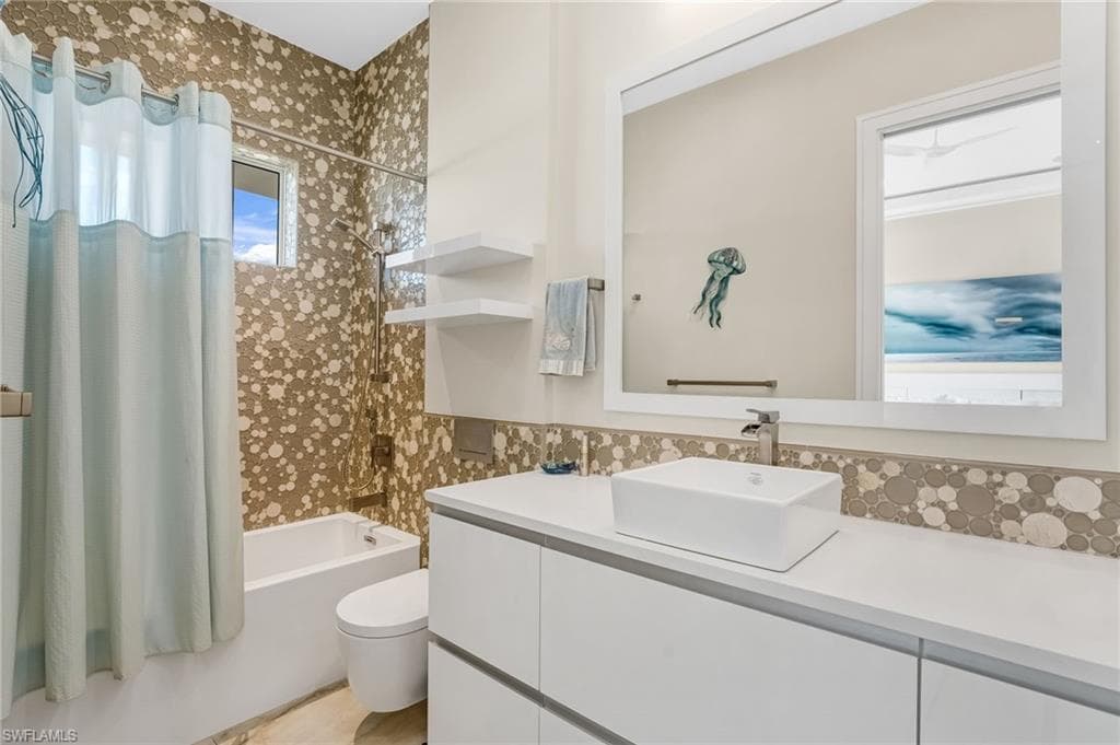 The sleek Scan Design second full bath features striking floor-to-ceiling tile and an upgraded shower-tub combination, beautifully enhanced by an abundance of natural light for a clean, modern feel.
