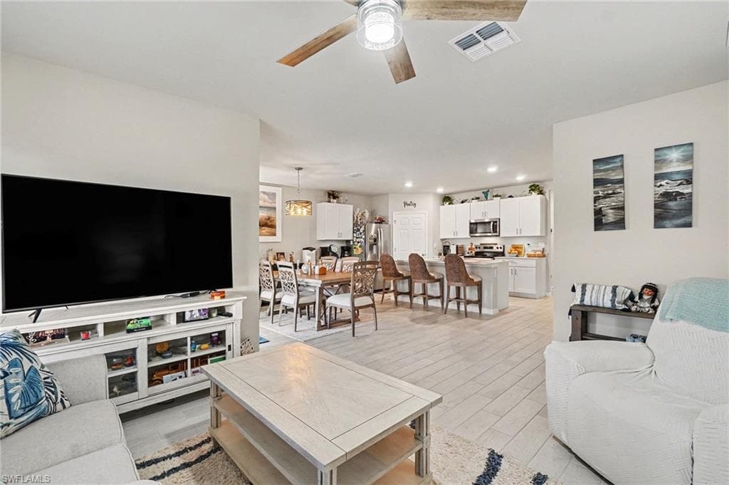Living room with a ceiling fan and light wood finished floors