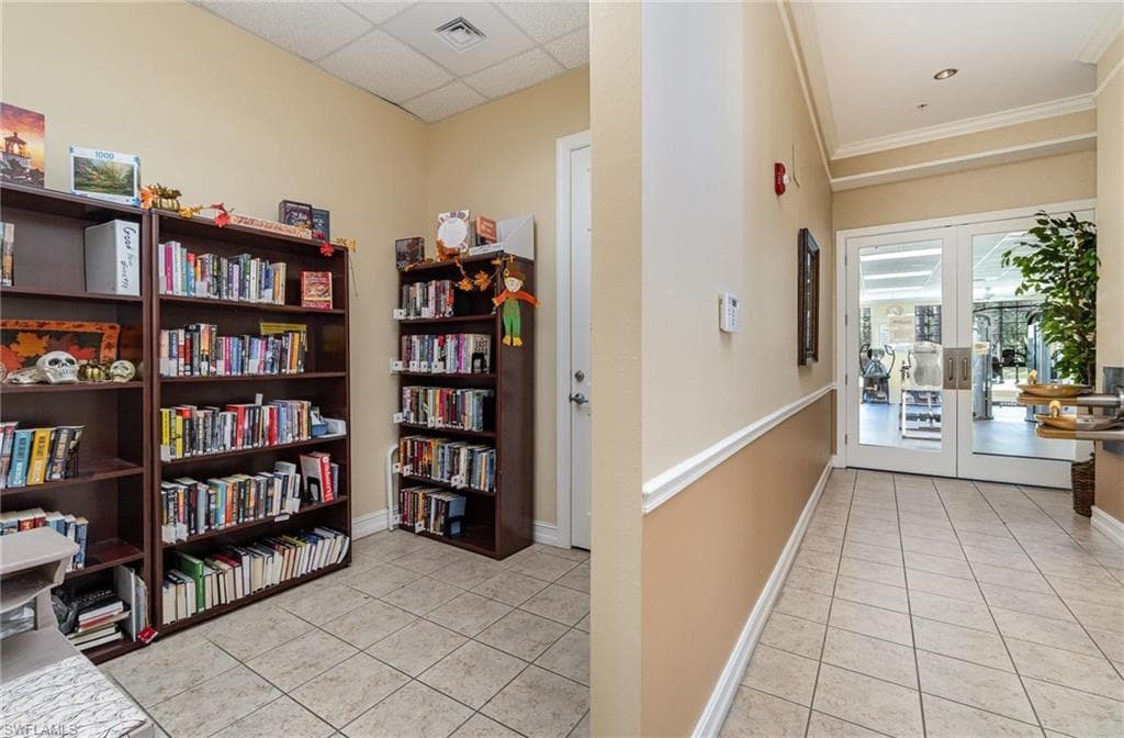 Corridor with light tile patterned floors and french doors