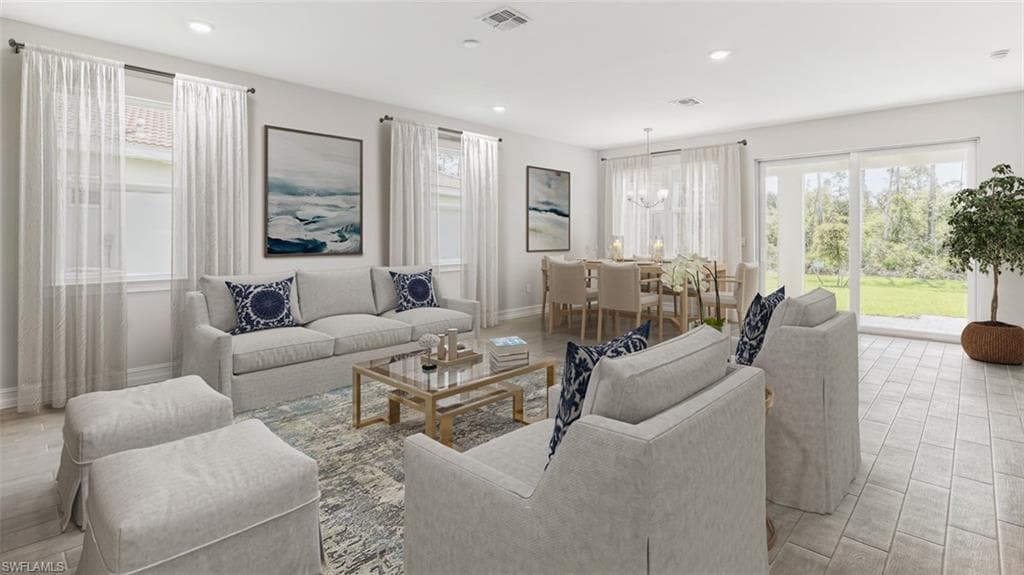 This image is virtually staged. Living room featuring light wood finished floors and hanging lights