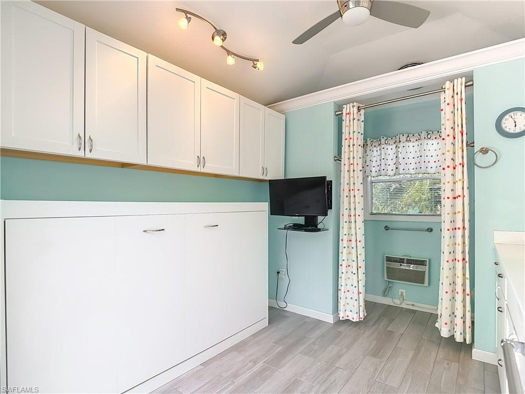 Laundry area with light wood-style floors, ceiling fan, and ornamental molding