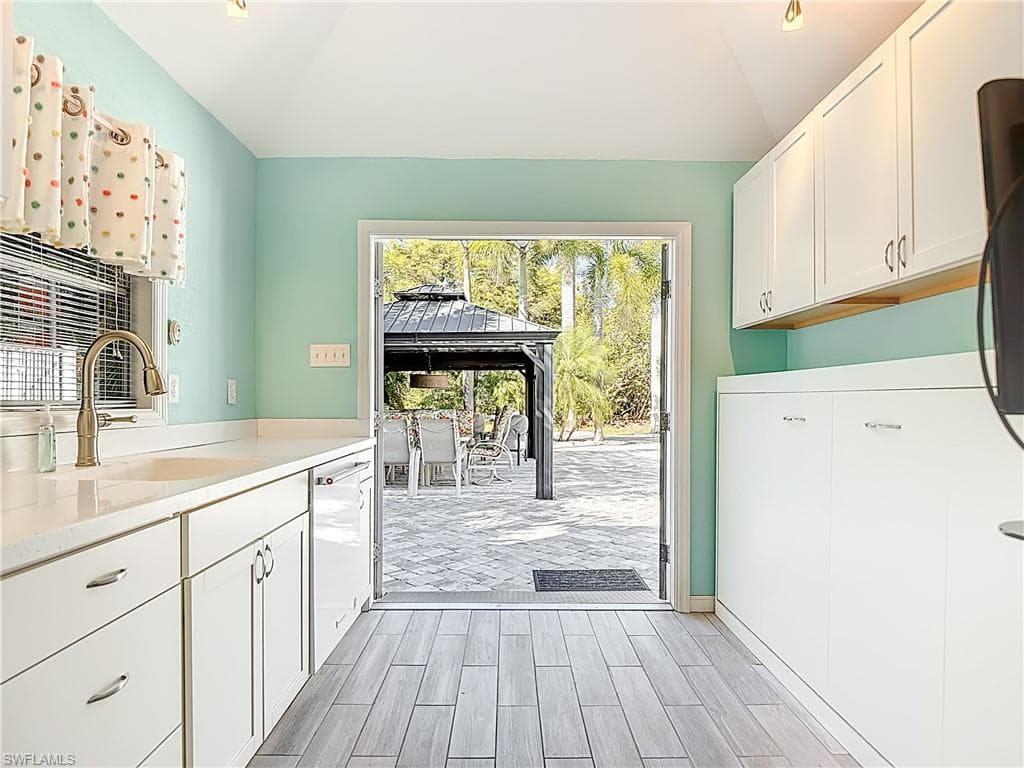 Laundry room featuring wood finish floors, ceiling, and cabinet space