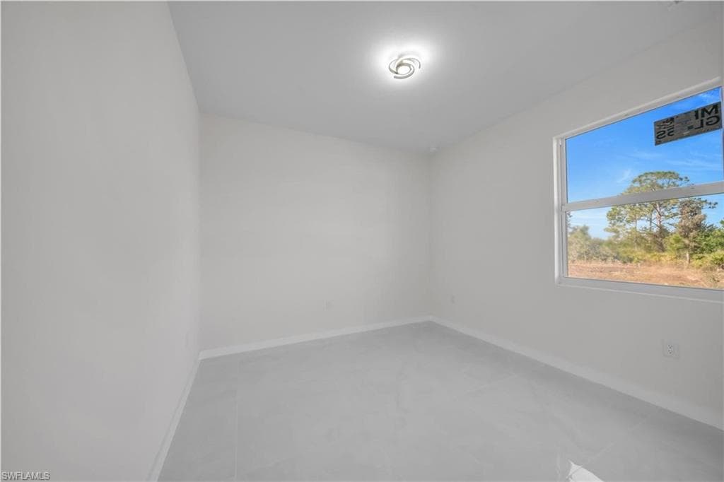 Spare room featuring baseboards